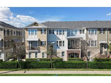 Charming townhome showcasing a well-maintained lawn, manicured hedges, and a welcoming brick staircase leading to the entrance at 450 Windmill Palm Cir, Altamonte Springs, FL 32701