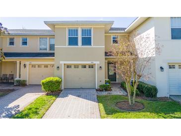 Inviting townhome with a well-manicured lawn and a single-car garage with a neutral colored door at 5412 Caramella Dr, Orlando, FL 32829