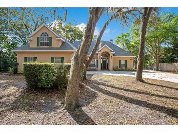Charming single-Gathering home featuring a manicured lawn, mature trees, and a welcoming facade at 5850 Sheryl Anita St, Oviedo, FL 32765