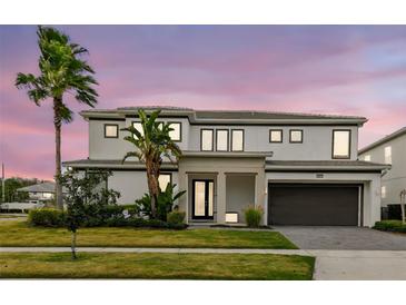 Stunning two-story home showcasing modern architecture and lush landscaping, complete with a palm tree at 3881 Sonoma Blvd, Kissimmee, FL 34741