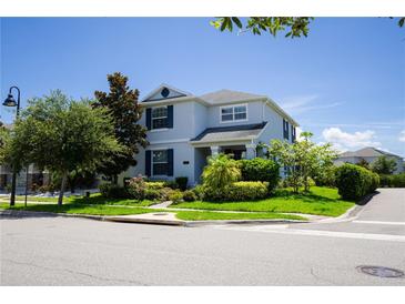 Charming two-story home with blue shutters and meticulously landscaped front yard, creating a welcoming curb appeal at 11810 Imaginary Way, Orlando, FL 32832