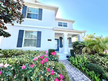 Beautiful two-story home with lush landscaping, blue shutters, and a charming brick walkway at 11810 Imaginary Way, Orlando, FL 32832
