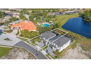 Aerial view of a property close to a pond and amenities, including a pool and clubhouse at 1205 Butterfly Orchid Rd, Davenport, FL 33837