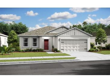 Charming single-story home with a gray exterior, red door, attached garage, and well-manicured lawn at 13252 Sw 85Th Cir # 58, Ocala, FL 34473