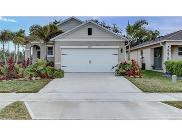 Inviting home exterior featuring a neutral color palette, an attached two-car garage and tropical landscaping at 2271 Delhi Pl, Sanford, FL 32771