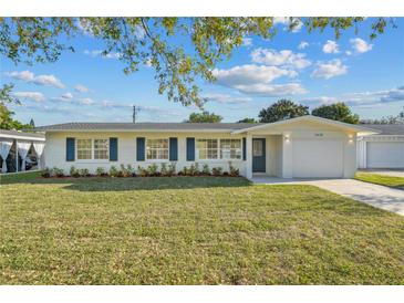 Charming single-story home featuring a well-manicured lawn and tasteful landscaping, creating a welcoming curb appeal at 2418 Whitehall Cir, Winter Park, FL 32792