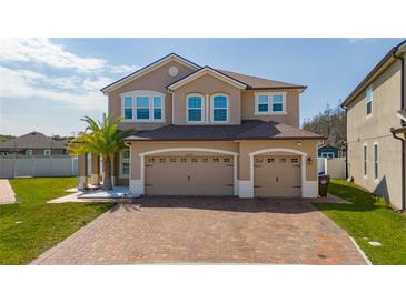 Charming two-story home featuring a three-car garage and a brick paver driveway at 2424 Varenna Loop, Kissimmee, FL 34741