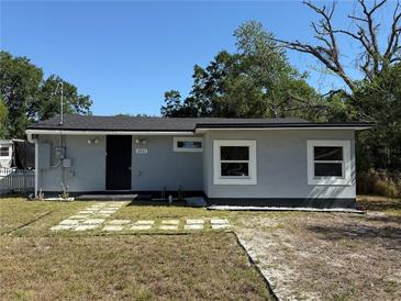 Charming single-story home featuring a well-manicured lawn and a welcoming black front door at 3931 Avenue R Nw, Winter Haven, FL 33881