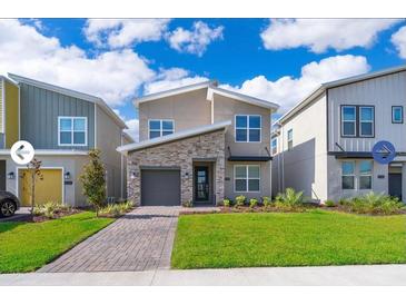 Beautiful two-story home with a modern design, stone accents, well-manicured lawn, and inviting curb appeal at 4338 Rhyme St, Kissimmee, FL 34746