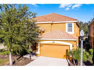Charming two-story home featuring an orange tile roof and attached garage at 5260 Oakbourne Ave, Davenport, FL 33837