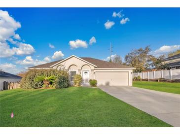 Charming single-story home features a well-maintained lawn and attached two-car garage at 9526 Water Fern Cir, Clermont, FL 34711