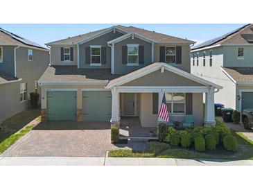 Charming two-story home with a brick driveway, covered porch, and manicured landscaping at 10732 Petrillo Way, Winter Garden, FL 34787