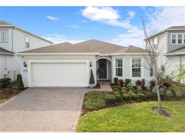 Charming home featuring a well-manicured lawn, lush landscaping, and a paved driveway at 13916 Destin Beach Ln, Orlando, FL 32827
