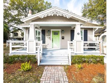 Charming bungalow with a covered porch, columns, decorative trim, and a vibrant green front door at 1513 Pinecrest Pl, Orlando, FL 32803