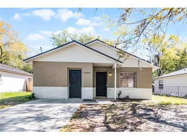 Charming single-Gathering home featuring dual entry doors, neutral paint, and white brick and siding accents at 2605 S Elm Ave, Sanford, FL 32773