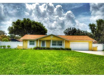 Charming single-story home featuring a lush green lawn and a welcoming yellow exterior at 333 Crystal Cir, Oviedo, FL 32765