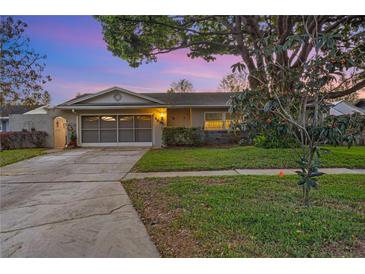 Charming single-story home featuring a well-maintained lawn and an attached two-car garage with a screen door at 4991 Tangerine Ave, Winter Park, FL 32792