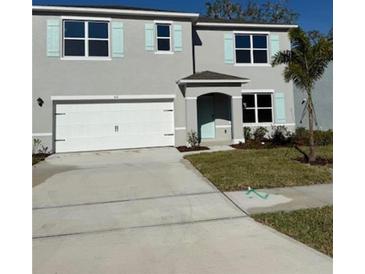 Charming two-story home with blue shutters, a two-car garage, and a well-maintained front yard at 512 Coronado Cove Rd, New Smyrna Beach, FL 32168