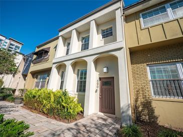 Attractive two-story townhome with light-colored exterior, arched entryway, and neatly landscaped front yard at 620 E Church St, Orlando, FL 32801