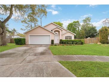 Charming single-story home featuring a well-maintained lawn, mature trees, and a two-car garage at 14026 Eckard Ct, Orlando, FL 32826