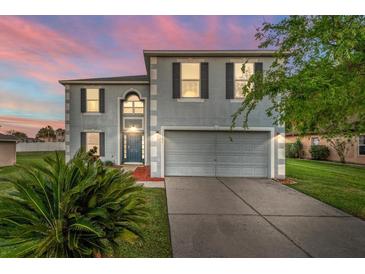 Charming two-story home with a well-maintained lawn and two car garage at sunset at 181 Zachary Wade St, Winter Garden, FL 34787