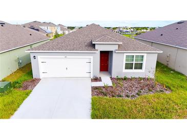 Charming single-story home with gray exterior, white garage door, and a neatly landscaped front yard at 1811 Silverbell Loop, Haines City, FL 33844