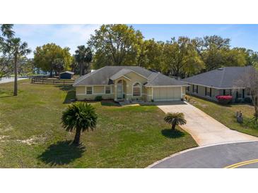Well-kept home with lush lawn, mature trees, and spacious driveway offers desirable curb appeal at 2011 Oakbend Dr, Eustis, FL 32726