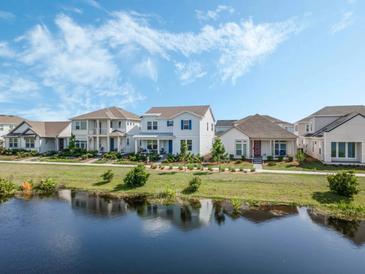 Beautiful exterior view of houses near a serene pond under a partly cloudy sky at 2970 Scout St, St Cloud, FL 34771