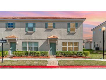 Charming townhome featuring a neatly landscaped front yard and a well-maintained exterior with updated windows at 3127 Via Otero Dr, Kissimmee, FL 34744