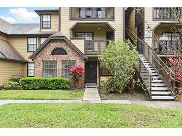 Charming condo exterior featuring brick accents, landscaped grounds, and convenient stairwell access to upper units at 320 Black Oak Ct # 102, Altamonte Springs, FL 32701