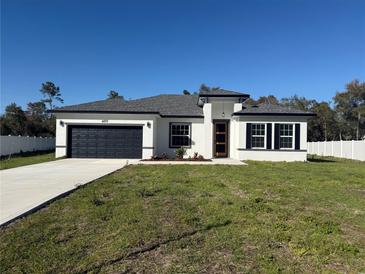 Charming single-Gathering home with a well-manicured lawn, a two-car garage, and a modern architectural style at 489 Marion Oaks Golf Rd, Ocala, FL 34473