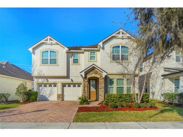 Charming two-story home with a brick driveway, two-car garage and manicured landscaping at 5029 Southlawn Ave, Orlando, FL 32811