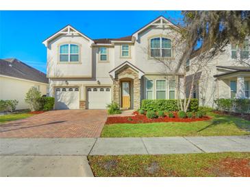 Charming two-story home features a brick driveway, two-car garage, and manicured landscaping at 5029 Southlawn Ave, Orlando, FL 32811