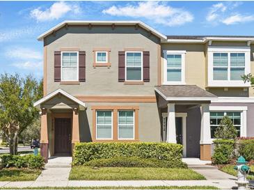 Charming townhome with neutral paint, brown shutters, and well-maintained front yard landscaping at 7776 Rigby St, Windermere, FL 34786