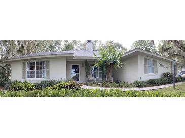 Charming single-story home with a welcoming entrance, lush landscaping, and neutral exterior paint at 2930 Westgate Dr, Eustis, FL 32726