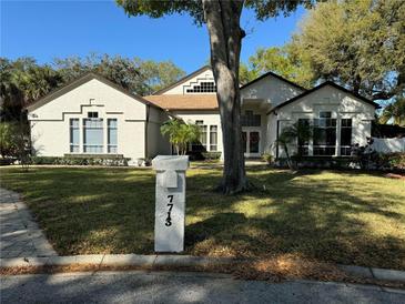 Charming two-story home with manicured lawn, mature trees, and inviting curb appeal in a serene neighborhood at 7713 Hidden Ivy Ct, Orlando, FL 32819