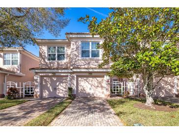 Charming townhome with a tile roof, brick driveway, and an attached two-car garage at 1290 Grady Ln # 20232, Davenport, FL 33896