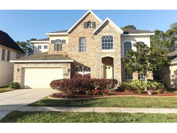 Charming two-story brick home with a well-manicured lawn, colorful plantings, and a two-car garage at 1924 Stonecrest Ct, Orlando, FL 32825