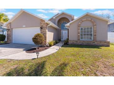 Charming home featuring a blend of stucco and brick accents and a well-manicured front lawn at 3043 Autumn Run Ct, Orlando, FL 32822