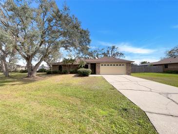 Charming single-story home with a well-manicured lawn and a two-car garage at 5030 Creekview Ln, Lakeland, FL 33811