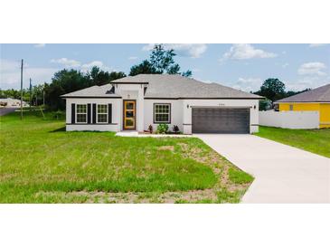 Modern exterior elevation showcasing the well-maintained lawn and neutral color palette with attractive gray trim at 6164 Sw 129Th St, Ocala, FL 34473