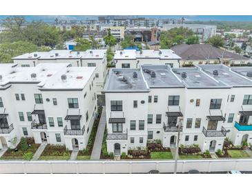 Modern townhomes with white exteriors and wrought iron balconies in a desirable urban neighborhood at 62 W Jersey St # 13, Orlando, FL 32806