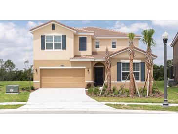 Charming two-story home with a two-car garage, landscaped yard, and a tile roof at 7699 Oakmoss Loop, Davenport, FL 33837