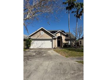 Charming single-story home with palm trees, garage and a well-maintained front yard at 10333 Crystal Point Dr, Orlando, FL 32825