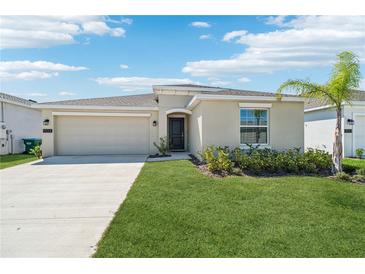 Charming single-story home featuring a well-manicured lawn, two car garage, and lush landscaping at 1533 Peach Creek Dr, Osteen, FL 32764