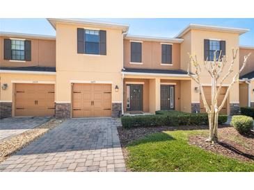 Charming two-story townhome featuring a well-manicured lawn, a one-car garage, and a welcoming front entrance at 1625 Smokey Oak Way, Longwood, FL 32750