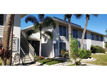 A condo building with stairs, landscaping, and a clean exterior with palm trees in the background at 1935 Conway Rd # R5, Orlando, FL 32812
