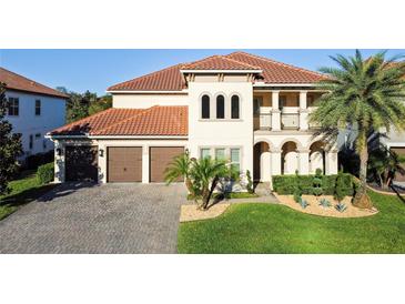 Stunning two-story home with a red tile roof, lush landscaping, and a paver driveway at 3687 Farm Bell Pl, Lake Mary, FL 32746