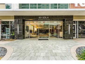 Contemporary building entrance with glass doors and gray stone accents at 101 S Eola Dr # 910, Orlando, FL 32801