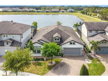 Beautiful lake view home with brick driveway, well-manicured lawn, and attached two-car garage at 5647 Barletta Dr, St Cloud, FL 34771